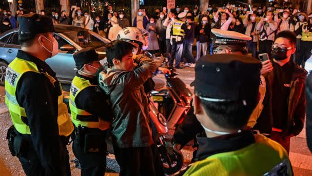 PHOTO: Police officers confront a man as they block Wulumuqi Street, Nov. 27, 2022, in Shanghai. (Hector Retamal/AFP via Getty Images)