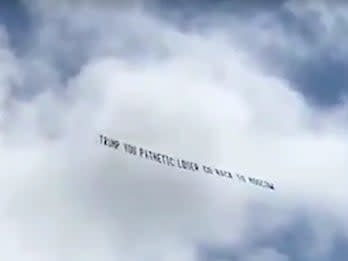 <p>The banner, captured on video flying overhead, read: ‘Trump you pathetic loser go back to Moscow'</p> (Paxton Boyd/ WPEC)