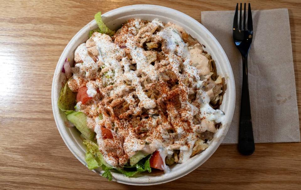 Combo bowl ( lamb, basmati rice, romaine lettuce, onions, tomatoes, cucumbers topped with tzatziki and spicy yogurt) at Nick the Greek restaurant in Riverbank, Calif., Tuesday, September 12, 2023.