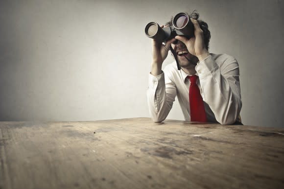 An investor looking through binoculars.