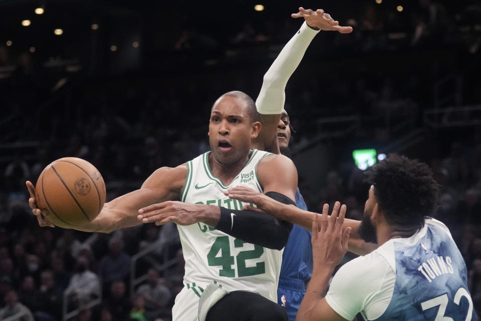 Boston Celtics center Al Horford (42) grabs the ball ball next to Minnesota Timberwolves center Karl-Anthony Towns (32) during the first half of an NBA basketball game Wednesday, Jan. 10, 2024, in Boston. (AP Photo/Charles Krupa)