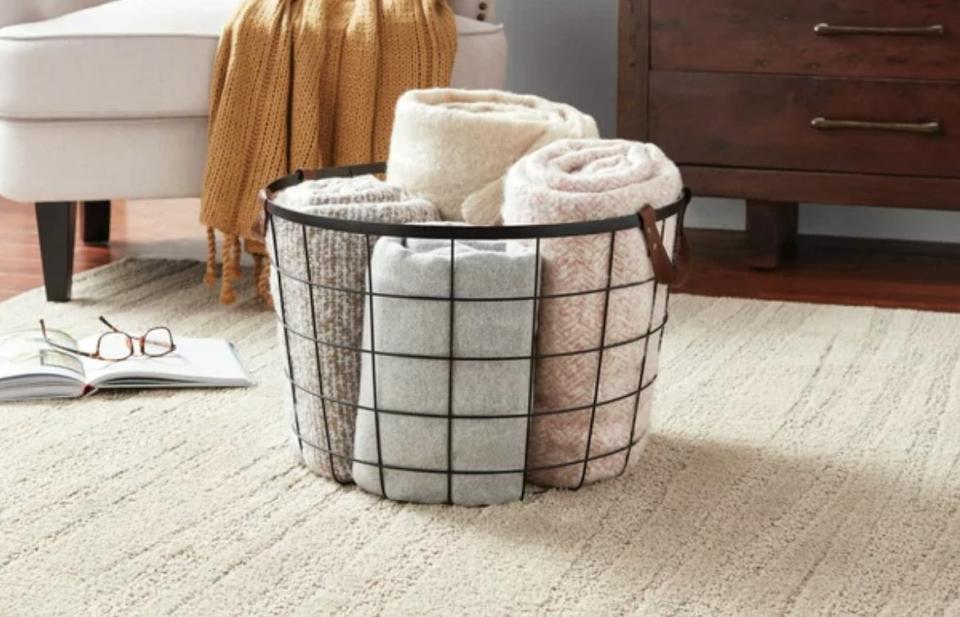 A wire basket with towels in it