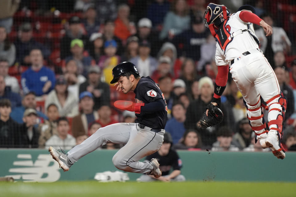 Cleveland Guardians' Steven Kwan, left, scores as Boston Red Sox's Connor Wong, right, is unable to tag him during the 11th inning of a baseball game Tuesday, April 16, 2024, in Boston. (AP Photo/Steven Senne)