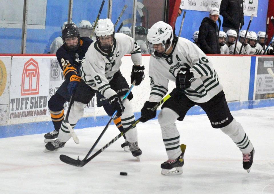 Battling for a loose puck are from left, Cohasset/Hull's Michael Corwin, and Abington's Evan St. Martin and Hunter Grafton during boys high school hockey at the Rockland Ice Rink, Monday, Feb. 12, 2024.