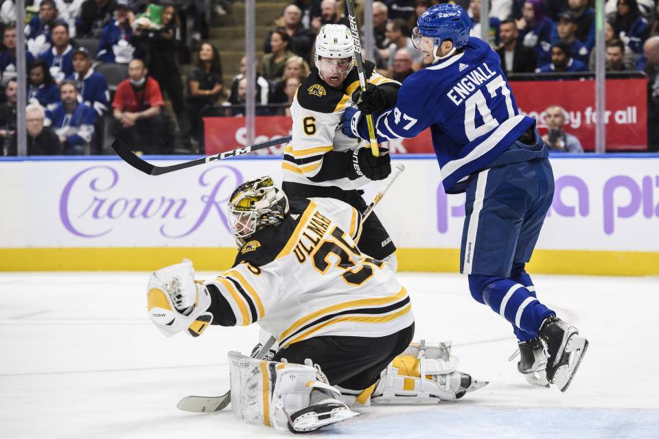 Toronto Maple Leafs forward Pierre Engvall (47) and Boston Bruins defenseman Mike Reilly (6) jostle for position in front of the net while Boston Bruins goaltender Linus Ullmark (35) makes a save during the second period of an NHL hockey game, Saturday, Nov. 5, 2022 in Toronto. (Christopher Katsarov/The Canadian Press via AP)