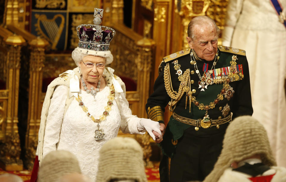 LONDON, ENGLAND - MAY 18:  Prince Philip, Duke of Edinburg holds the hand of Queen Elizabeth II as they look at the assembled lawmakers after she read the Queen's Speechon from the thrown during State Opening of Parliament in the House of Lords at the Palace of Westminster on May 18, 2016 in London, England. The State Opening of Parliament is the formal start of the parliamentary year. This year's Queen's Speech, setting out the government's agenda for the coming session, is expected to outline policy on prison reform, tuition fee rises and reveal the potential site of a UK spaceport. (Photo by Alastair Grant - WPA Pool/Getty Images)