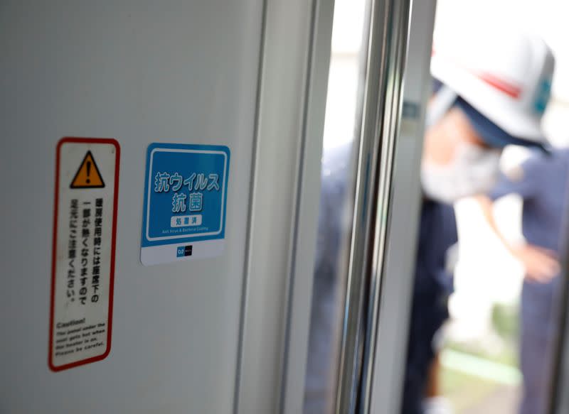 A sticker informing passengers about the task of anti-virus and bacteria coating procedures are displayed inside a railway car in Tokyo