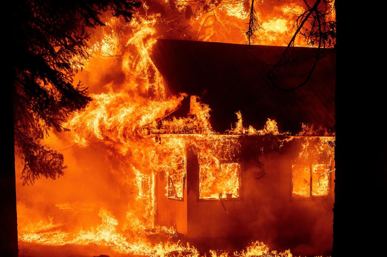 Flames consume a home as the Dixie Fire tears through the Indian Falls community in Plumas County, Calif. on Saturday, July 24, 2021.