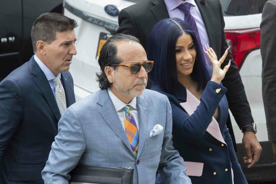 Grammy-winning rapper Cardi B, right, waves at fans as she arrives for a hearing at Queens County Criminal Court, Tuesday, June 25, 2019, in New York. (AP Photo/Mary Altaffer)