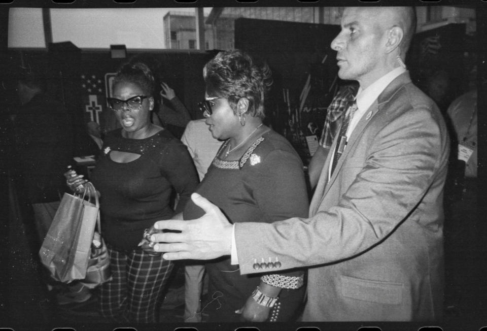 Herneitha Rochelle Hardaway, known as “Silk”, center, is escorted by security through media row at CPAC in National Harbor, Md., on March 3, 2023. (Frank Thorp V / NBC News)