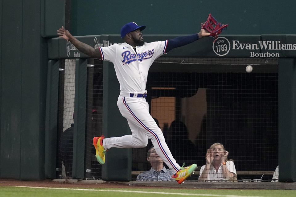 Texas Rangers right fielder Adolis Garcia makes an attempt to reach a foul ball hit by Boston Red Sox's Ceddanne Rafaela in the first inning of a baseball game, Wednesday, Sept. 20, 2023, in Arlington, Texas. (AP Photo/Tony Gutierrez)