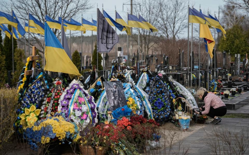 Woman cares on the grave of a relative killed in combat at the cemetery in Bucha, outskirts of Kyiv, Saturday March 30, 2024. Ukrainians mark the 2nd anniversary of the liberation of Bucha Sunday.