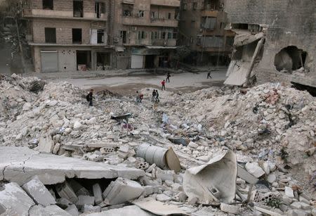 People walk on the rubble of damaged buildings in the rebel held area of al-Kalaseh neighbourhood of Aleppo, Syria, September 29, 2016. REUTERS/Abdalrhman Ismail