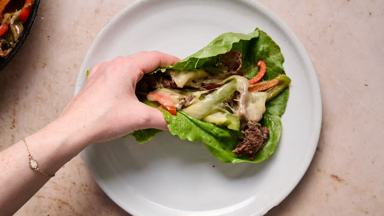 grabbing lettuce wrap on plate