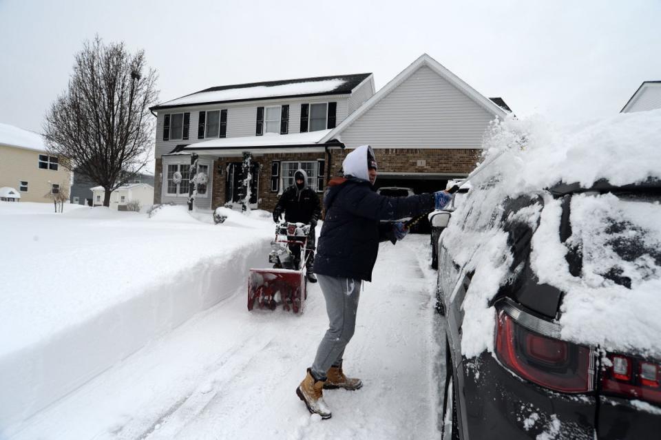 Jerry and Aidan Hughes clear snow from their home in West Seneca, New York (Getty Images)