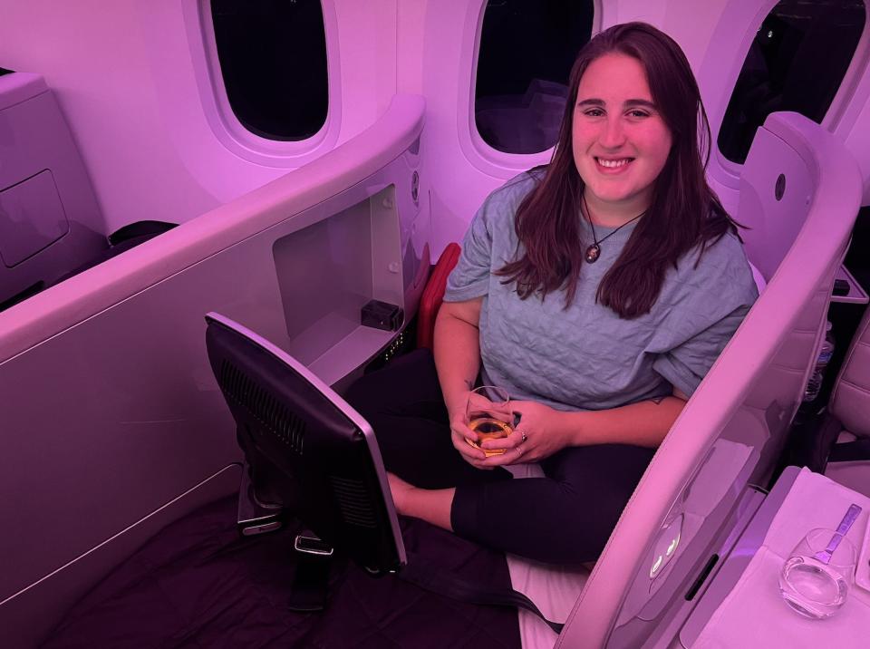 The author posing for a photo while in her seat on an Air New Zealand flight.