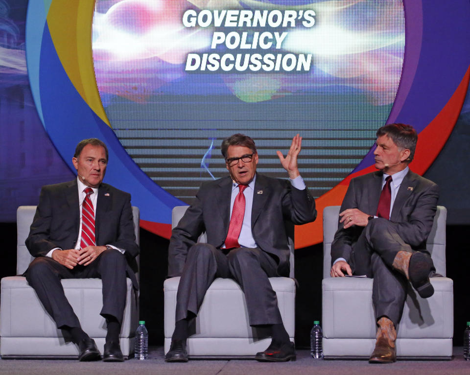 U.S. Energy Secretary Rick Perry, center, speaks as Utah Gov. Gary Herbert, left, and and Wyoming Gov. Mark Gordon, right, look on at an energy summit Thursday, May 30, 2019, in Salt Lake City. (AP Photo/Rick Bowmer)