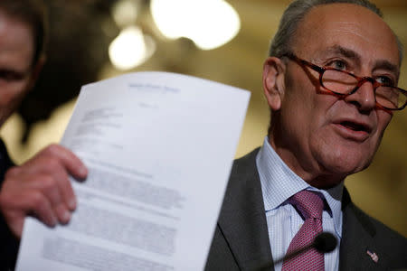 Senate Minority Leader Chuck Schumer holds up a letter about tax policy sent by Democrats to the Republican leadership as he speaks with reporters following the party luncheons on Capitol Hill in Washington, U.S., August 1, 2017. REUTERS/Aaron P. Bernstein