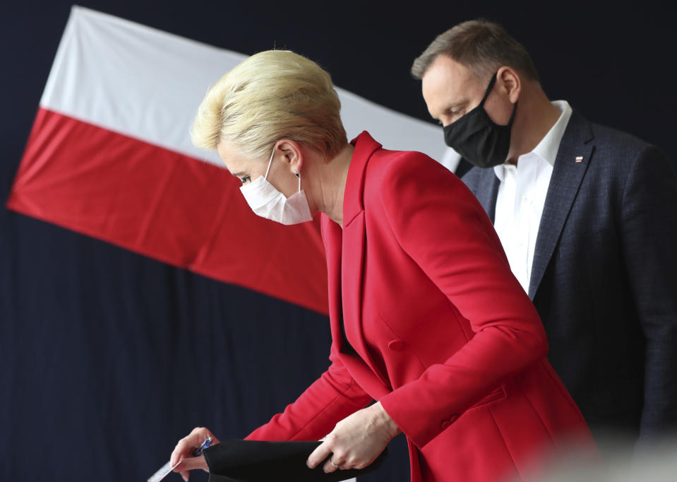 Candidate in Poland's tight presidential election runoff, incumbent President Andrzej Duda,right, and First Lady Agata Kornhauser-Duda ,left, cast their ballots at a polling station in their hometown of Krakow, Poland, on Sunday, July 12, 2020. Conservative Duda is running against liberal Warsaw Mayor Rafal Trzaskowski and latest opinion polls suggest the race will be decided by a very narrow margin.(AP Photo/Czarek Sokolowski)