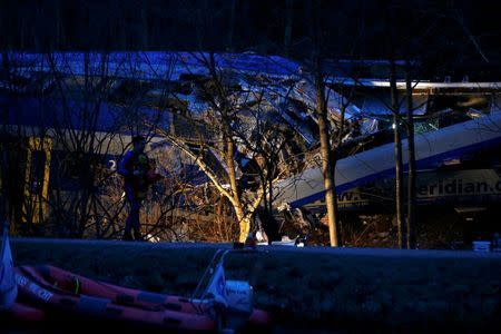 A member of emergency services walks at the site of two crashed trains near Bad Aibling in southwestern Germany, February 9, 2016. REUTERS/Michael Dalder