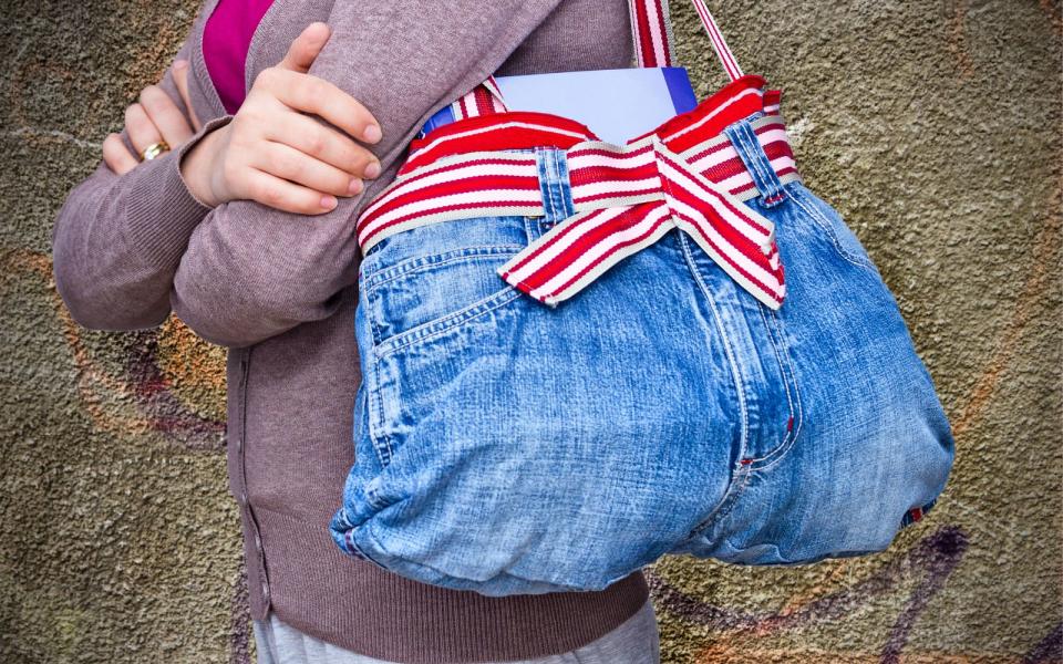 Alte Shirts und Hosen schmeißt man nicht in den Müll, sondern gibt sie in die Altkleidersammlung. Sie können sich allerdings auch noch als Designer versuchen und zum Beispiel aus einer Jeans eine praktische Einkaufstasche nähen. Im Internet finden Sie jede Menge Video-Anleitungen. (Bild: iStock / marugod83)