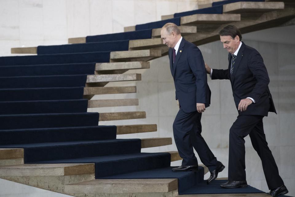 Russia's President Vladimir Putin, left, and Brazil's President Jair Bolsonaro walk to attend the meeting of the BRICS emerging economies at the Itamaraty palace in Brasilia, Brazil, Thursday, Nov. 14, 2019. (AP Photo/Pavel Golovkin, Pool)