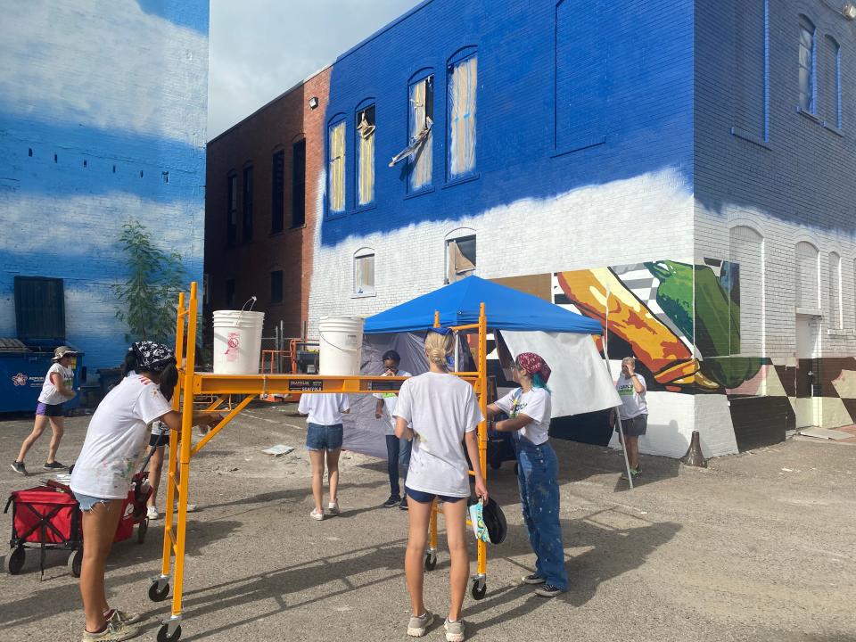 Teen artists lay out the bottom row of a mural on Chaparral Street through the K Space Contemporary Mural Arts program Thursday.