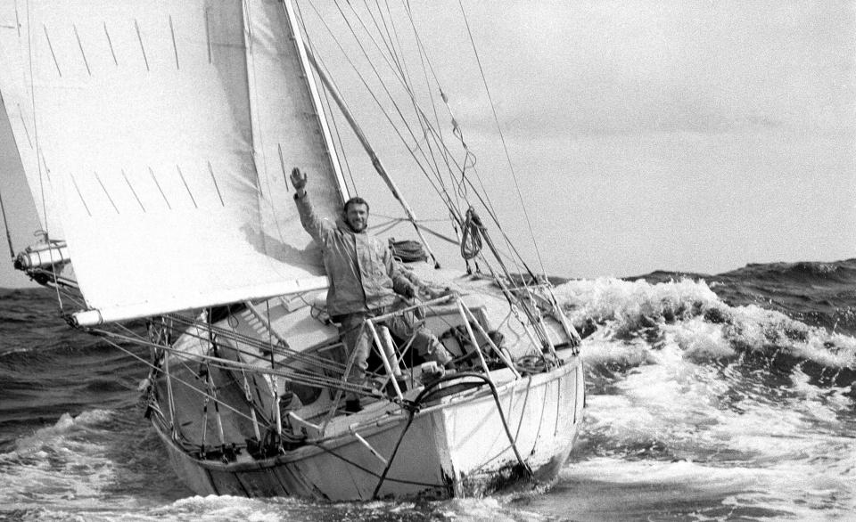 This 1969 photo provided by Bill Rowntree/PPL Media shows Robin Knox-Johnston waving aboard his 32-foot yacht Suhaili off the coast of Falmouth, England, after becoming the first man to sail solo non-stop around the globe. In the spring of 1969, less than three months before man landed on the moon, Knox-Johnston achieved the nautical equivalent of climbing Mount Everest when he became the first man to sail alone around the world nonstop. GPS hadn't been invented, so the veteran of the British merchant navy made his way around the globe the old-fashioned way, with a sextant. (Bill Rowntree/PPL Media via AP)