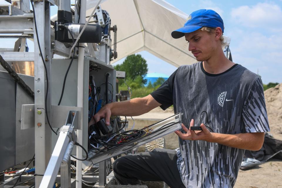 Carter Waggoner, a senior mechanical engineering major at SDSU, checks the panel on the main excavator during NASA's Break the Ice challenge in Brookings, South Dakota on Wednesday, Aug. 9, 2023.