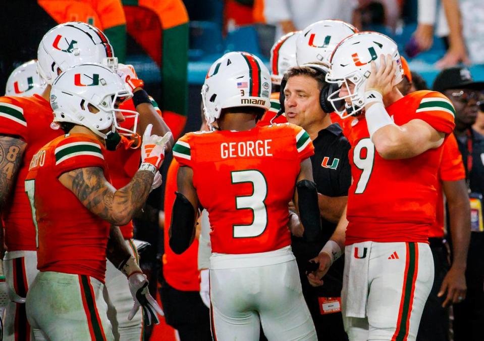 Miami Hurricanes Offensive Coordinator / Quarterbacks Coach Shannon Dawson talk with Hurricanes wide receivers Xavier Restrepo (7) Jacolby George (3) and Hurricanes quarterback Tyler Van Dyke (9) during the fourth quarter of an NCAA non conference game against Texas A&M at Hard Rock Stadium on Saturday, Sept. 9, 2023 in Miami Gardens, Florida.