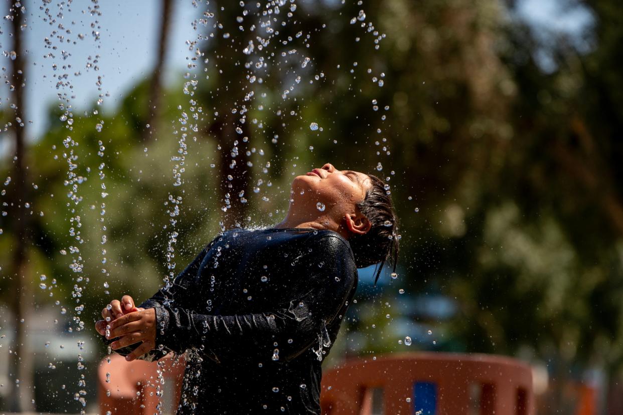 Eztli Nunez cools off in the water feature at North Indio Park in Indio, Calif., on June 4, 2023. 