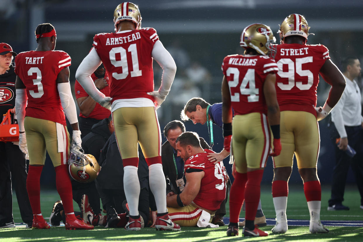 Nick Bosa #97 of the San Francisco 49ers down on the field with an injury during the second quarter against the Dallas Cowboys in the NFC Wild Card Playoff game at AT&T Stadium on January 16, 2022 in Arlington, Texas. (Photo by Tom Pennington/Getty Images)