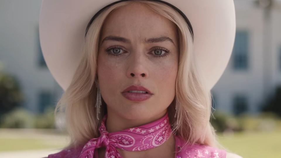 Margot Robbie's Barbie in pink and a cowboy hat with a single tear running down her face