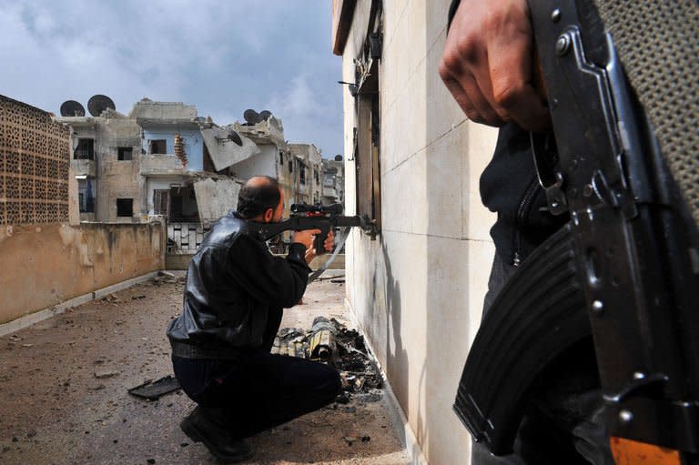 A rebel fighter shoots towards Syrian government forces through a window at a flat in the Salaheddine neighbourhood of Aleppo on February 16, 2013. An apparent surface-to-surface missile attack flattened a residential area of Aleppo city on Monday, killing at least 31 people, the Syrian Observatory for Human Rights said on Tuesday