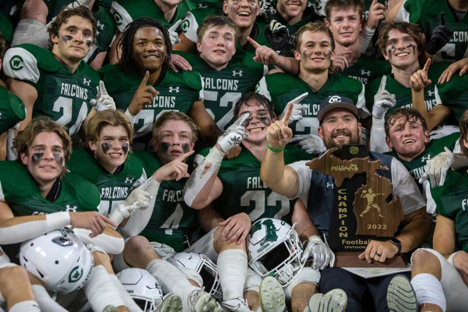 Grand Rapids West Catholic players hold a trophy after the 59-14 win in the Division 6 state final at Ford Field on Friday, Nov. 25, 2022.