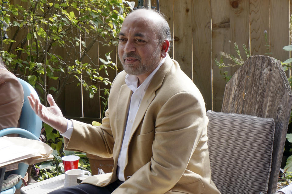 Zafar Siddiqui addresses the “India Coalition” group in the backyard of two members’ Minneapolis home on Sunday, Oct. 9, 2022. Siddiqui, who’s Muslim, has helped bring together the interfaith group of Minnesotans of Indian origin to “build bridges” in the community. (AP Photo/Giovanna Dell’Orto)