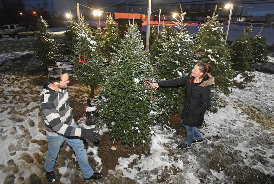 Brian Huster, 41, left, and his wife, Akaris Huster, 40, of Erie, choose a 7-foot-tall Fraser fir Christmas tree on Monday at A u0026 J's Trees, 5675 Wattsburg Road in Millcreek Township.