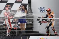 Andrea Dovizioso, left, of Italy and Marc Marquez, right, of Spain, spray each other on the winners podium following the Grand Prix of the Americas MotoGP motorcycle race, Sunday, April 13, 2014, in Austin, Texas. Marquez won the race, Doviizioso came in third with Dani Pedrosa finishing in second place. (AP Photo/Tony Gutierrez)