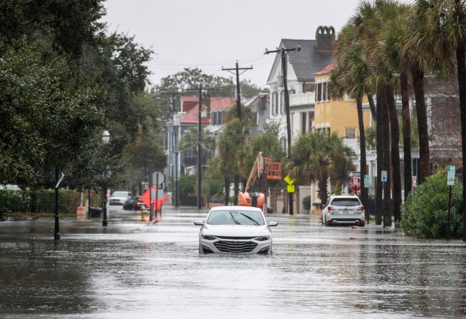 A car drives through a flooded street near the Battery on Sunday (AP)
