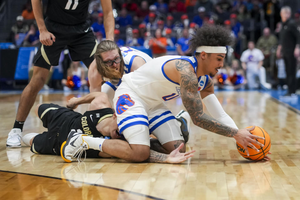 Boise State guard Roddie Anderson III, right, reaches for the loose ball against Colorado guard KJ Simpson, left, during the first half of a First Four game in the NCAA men's college basketball tournament Wednesday, March 20, 2024, in Dayton, Ohio. (AP Photo/Aaron Doster)