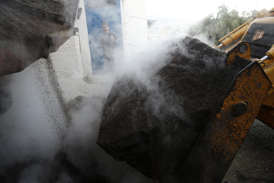 A truck loads steaming olive pomace, the remains of olives after being pressed, are collected to be used to help power a nearby olive oil production plant in Velanidi village, 320 kilometers (200 miles) west of Athens, Greece on Thursday, Nov. 28, 2013. Greece remains the highest consumer of olive oil per capita in the world despite the country's ongoing financial crisis. (AP Photo/Petros Giannakouris)