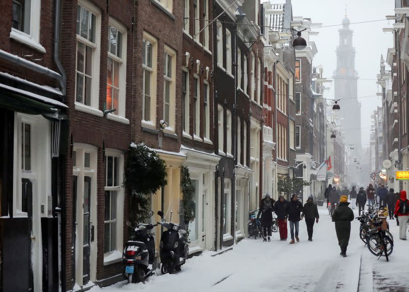 FILE PHOTO: People walk after heavy snowfall in Amsterdam