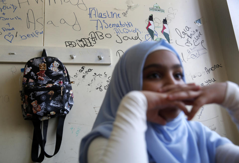 A Palestinian refugee student sits inside her classroom as she attends the first day of a new school year, at one of the UNRWA schools, in Beirut, Lebanon, Monday, Sept. 3, 2018. The United Nations' Palestinian relief agency celebrated the start of the school year in Lebanon on Monday, managing to open its schools on schedule despite a multi-million dollar budget cut on the heels of U.S. President Donald Trump's decision to stop funding to the agency. (AP Photo/Hussein Malla)