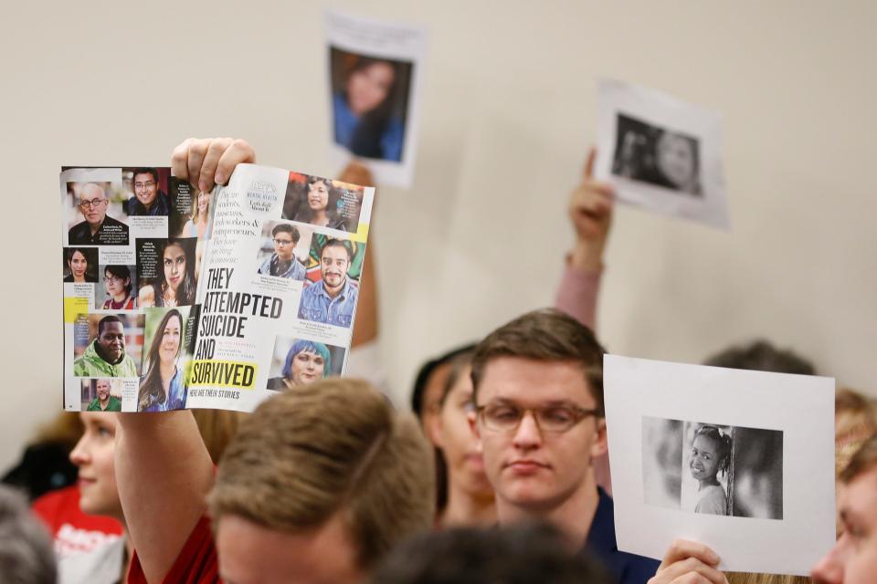 Supporters of gun control hold up photos of gun violence victims during a meeting of the Senate Judiciary committee at the Capitol in Richmond, Va., on Jan. 13.