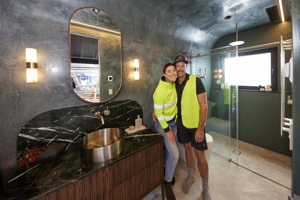 Leah and Ash pose smiling and hugging in their bathroom