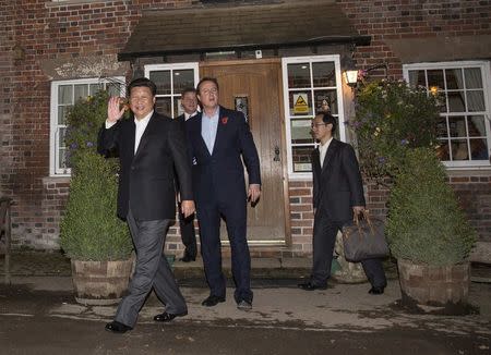 Britain's then Prime Minister David Cameron and China's President Xi Jinping leave The Plough At Cadsden pub in Cadsden, Britain in this file October 22, 2015 photo. REUTERS/Eddie Keogh/File Photo