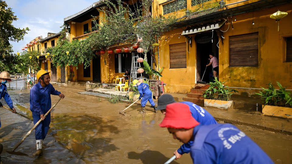 Municipal workers and residents clean up the streets after waters receded in the old city of Hoi An, a UNESCO world heritage site, on October 30, 2020, in the aftermath of Typhoon Molave. - Manan Vatsyayana/AFP/Getty Images