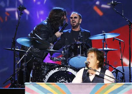 Dave Grohl (L) sings with Ringo Starr as Paul McCartney (Front) performs during the taping of "The Night That Changed America: A GRAMMY Salute To The Beatles", which commemorates the 50th anniversary of The Beatles appearance on the Ed Sullivan Show, in Los Angeles January 27, 2014. REUTERS/Mario Anzuoni