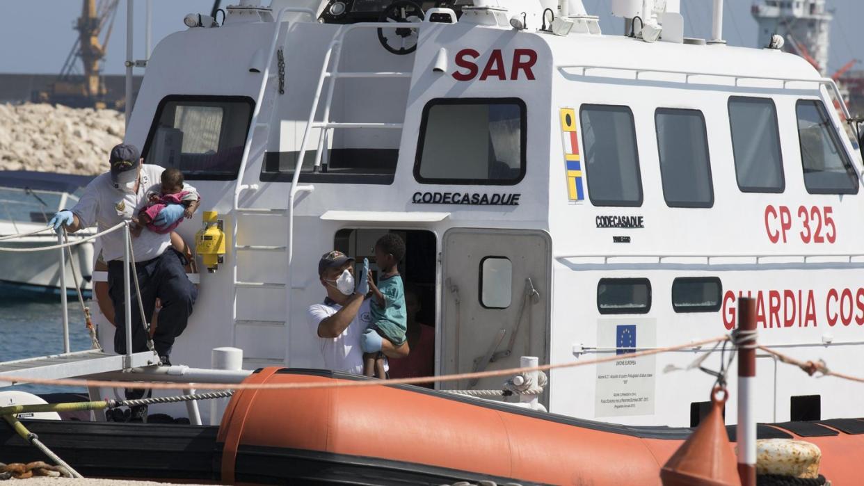 Sanitäter tragen in Pozzallo (Sizilien) Kinder von Bord eines Schiffes der italienischen Küstenwache. Foto: Francesco Ruta/ANSA/AP