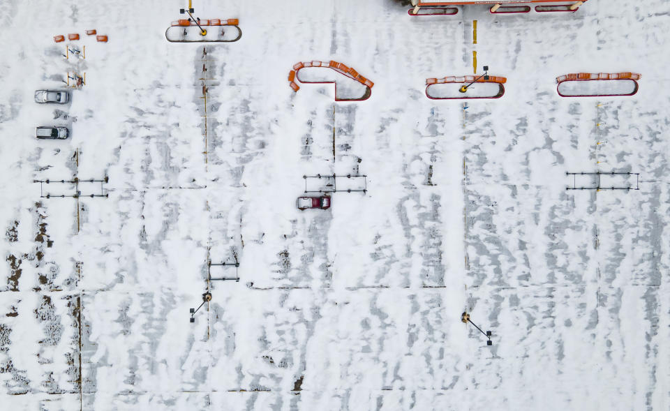 A Home Depot parking lot is covered in snow in the Westbury neighborhood, Monday, Feb. 15, 2021, in Houston. A winter storm making its way from the southern Plains to the Northeast is affecting air travel. (Mark Mulligan/Houston Chronicle via AP)